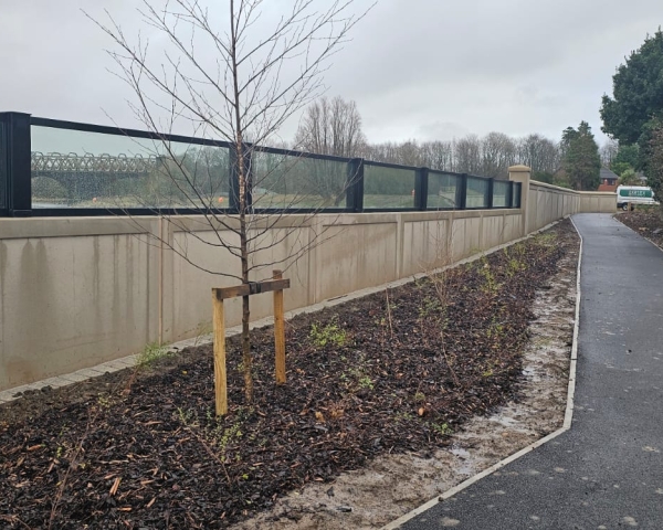 Glass flood panels a top a concrete wall by a river