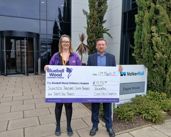 Two people holding a big cheque